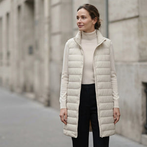 Doudoune longue beige sans manche femme portee, capuche et ligne longue jusqu'a la cuisse