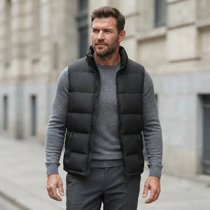 Homme portant la Doudoune sans Manche noire, maille col rond grise et pantalon anthracite