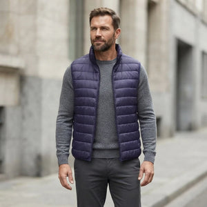 Homme portant la Doudoune sans Manche Homme Sport bleu marine, maille col rond grise et pantalon anthracite