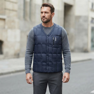 Homme portant la Doudoune sans Manche Plume Homme bleu marine, maille col rond grise et pantalon anthracite