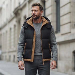 Homme portant la Doudoune sans Manche bicolore noir et caramel, maille col rond grise et pantalon anthracite