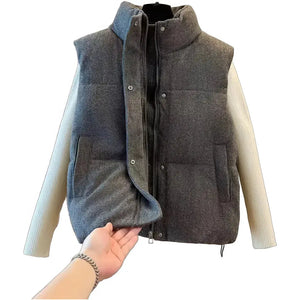 Doudoune sans manche bronze gris foncé ouverte, fermeture zippée doublée de pressions, sur un pull