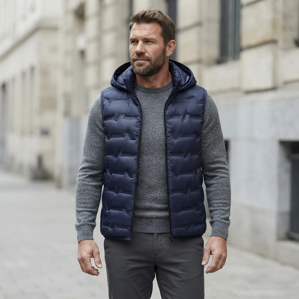 Homme portant la Doudoune sans Manche Haut de Gamme bleu marine, maille col rond grise et pantalon anthracite