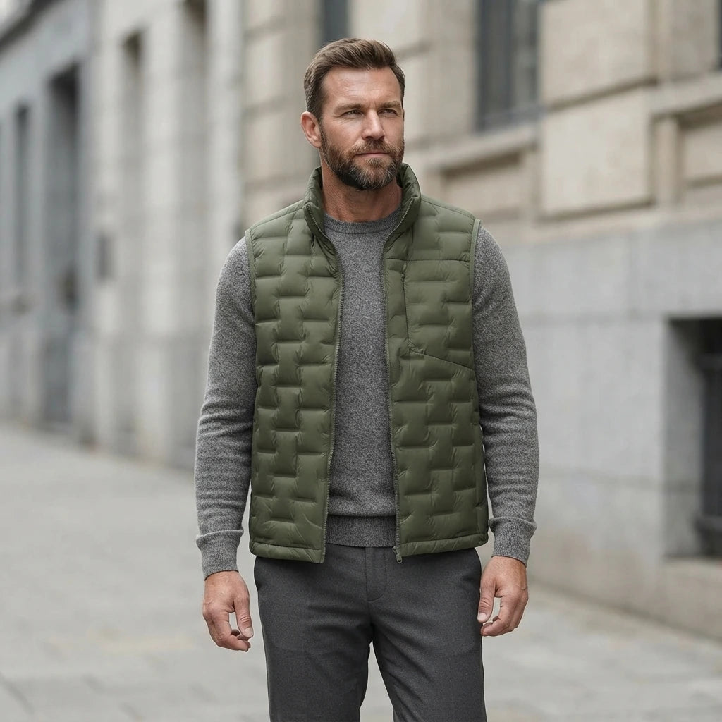 Homme portant la Doudoune sans Manche verte, maille col rond grise et pantalon anthracite