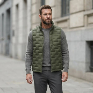 Homme portant la Doudoune sans Manche verte, maille col rond grise et pantalon anthracite