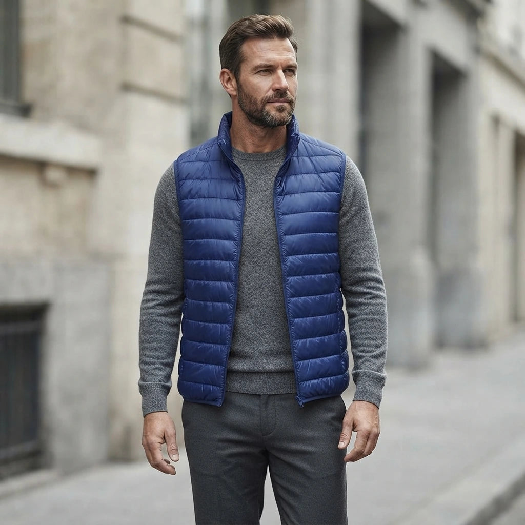 Homme portant la Doudoune sans Manche Légère Homme bleu roi, maille col rond grise et pantalon anthracite