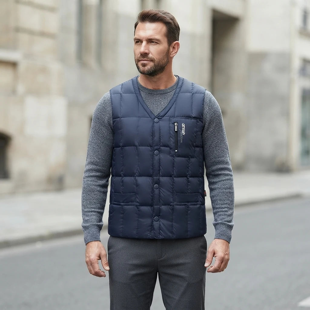 Homme portant la Doudoune sans Manche Plume Homme bleu marine, maille col rond grise et pantalon anthracite