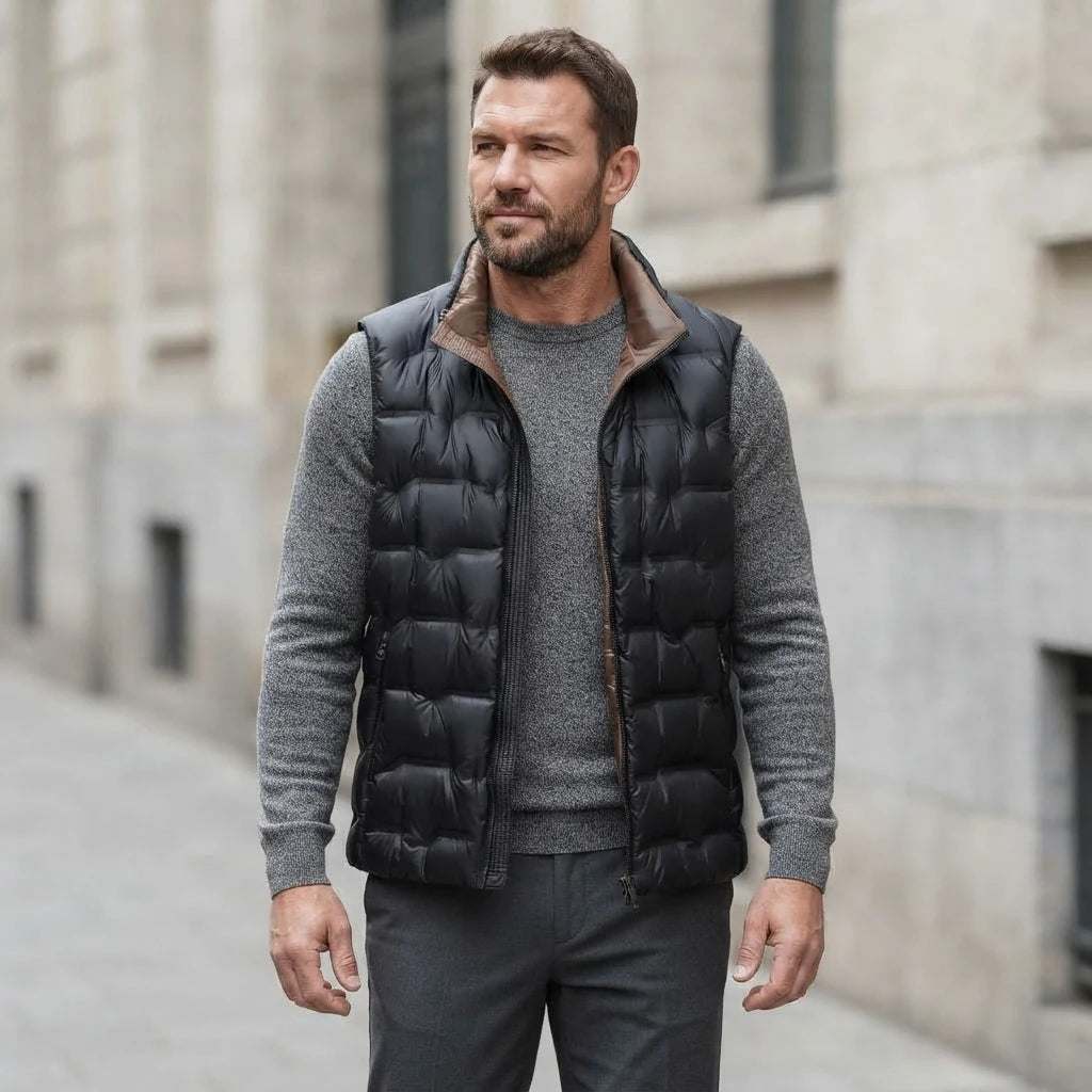 Homme portant la Doudoune sans Manche Satinée Homme noir, maille col rond grise et pantalon anthracite